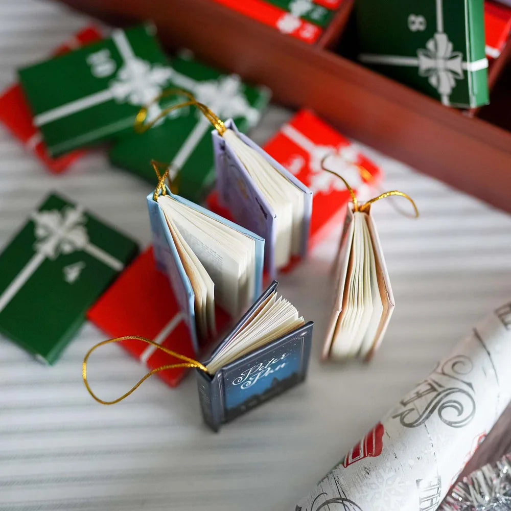 A close-up of a book-themed advent calendar featuring small books and ornaments in green, red, and gold packaging.
