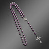A rosary necklace featuring purple beads and a vintage cross pendant on a silver chain.