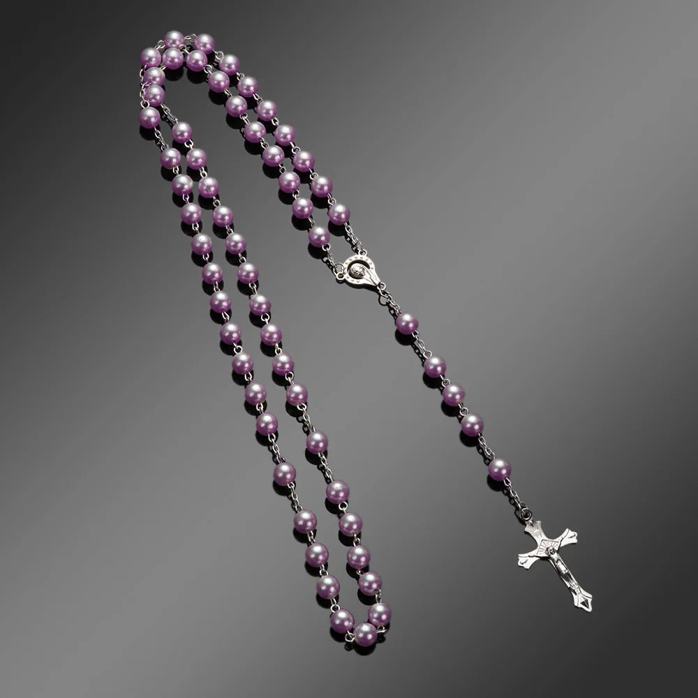 A rosary necklace featuring purple beads and a vintage cross pendant on a silver chain.