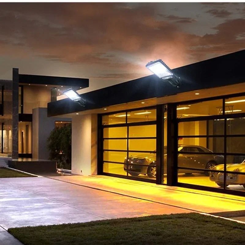 Exterior view of a modern building entrance featuring solar powered motion sensor security lights illuminating the driveway.