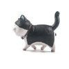 A black and white cartoon cat figurine used as a refrigerator magnet.