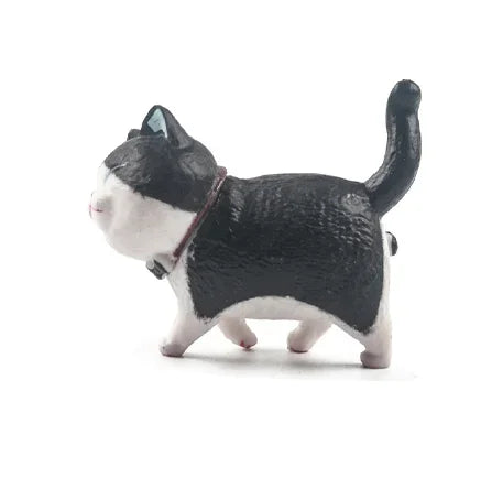 A black and white cartoon cat figurine used as a refrigerator magnet.