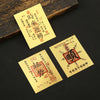 Two yellow paper stickers with red Chinese characters for lucky wealth and prosperity are displayed on a dark surface.
