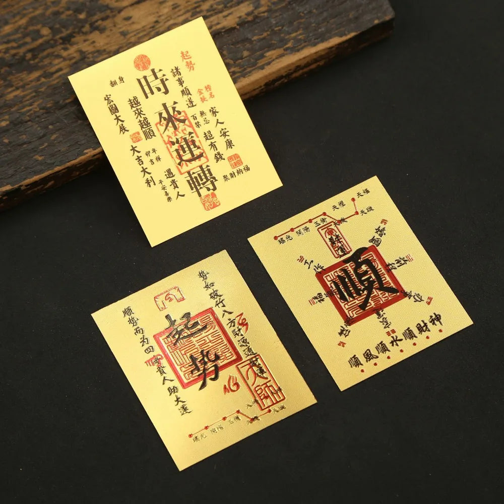 Two yellow paper stickers with red Chinese characters for lucky wealth and prosperity are displayed on a dark surface.