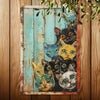 A vintage metal tin sign featuring multiple cats in various expressions and colors, displayed on a wooden background.