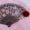 Vintage flamenco rose handheld folding fan with black and pink floral patterns