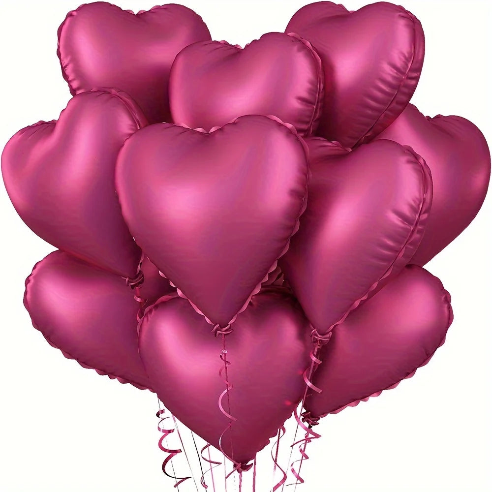 A cluster of ten glossy pink heart-shaped foil balloons tied together for a celebration.