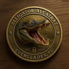 A round gold-toned collectible coin featuring a detailed alligator head design and text.