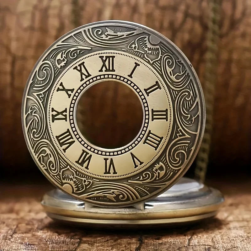Vintage bronze quartz pocket watch with a decorative engraved face and chain resting on wood.