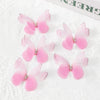 Pink and white fabric butterfly patches for crafts and decor displayed on white lace