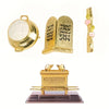 A gold metal statue depicting the Ark of the Covenant, featuring a lid and decorative elements.