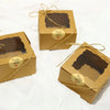 Three small kraft paper boxes with thank you tags tied with twine.