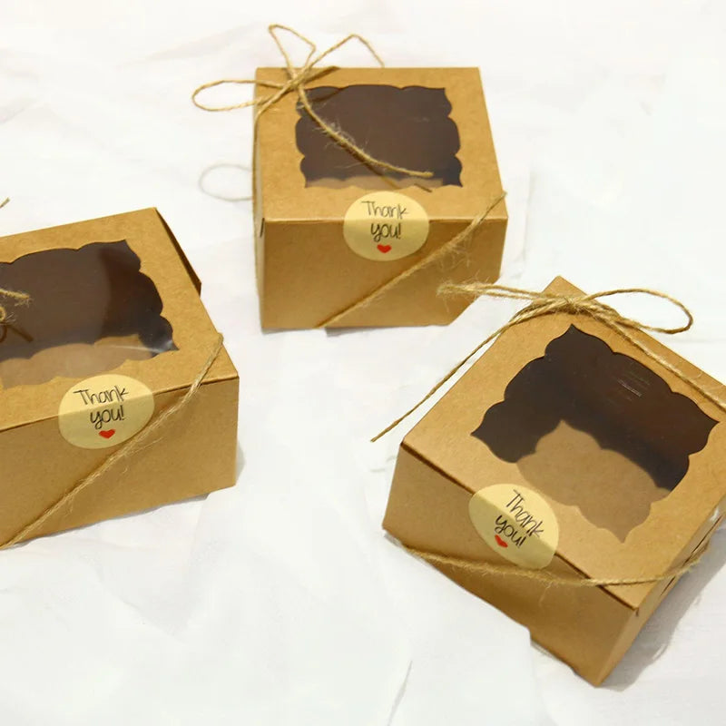 Three small kraft paper boxes with thank you tags tied with twine.