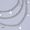 Silver Y2K star charm layered chain necklace displayed against a light purple background.
