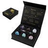 A black gift box containing a natural stone zodiac bracelet and various crystal quartz stones.