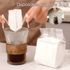 Disposable lug filter bags being used to brew coffee in a glass, with an inset showing the filter inside.