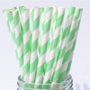 A bundle of white and green striped paper drinking straws in a glass container.