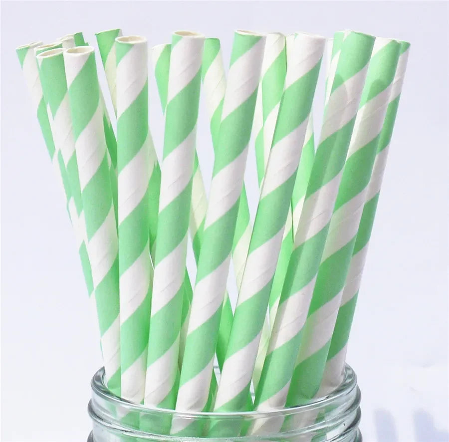 A bundle of white and green striped paper drinking straws in a glass container.