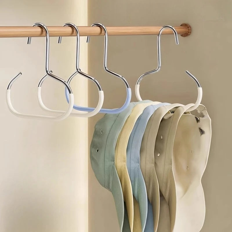 A wooden hanger bar holds several round metal hooks displaying various colored hats, ties, and scarves.