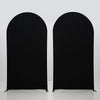 Two black stretchable arch backdrop covers standing upright against a white background.