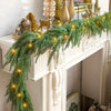 A realistic green Norfolk pine Christmas garland with warm lights draped over a white fireplace mantel.