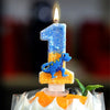 A birthday candle shaped like the number one featuring a blue dinosaur on an orange cake.