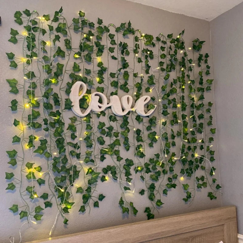 Artificial leaf string lights creating a green vine backdrop with the word love