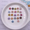A white plate holds a collection of 20 mixed color resin cheese and donut nail art charms.