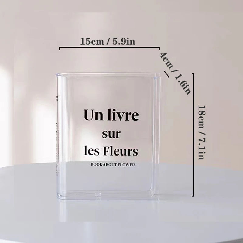 Clear acrylic book vase with flower holder showing dimensions and text on a white surface
