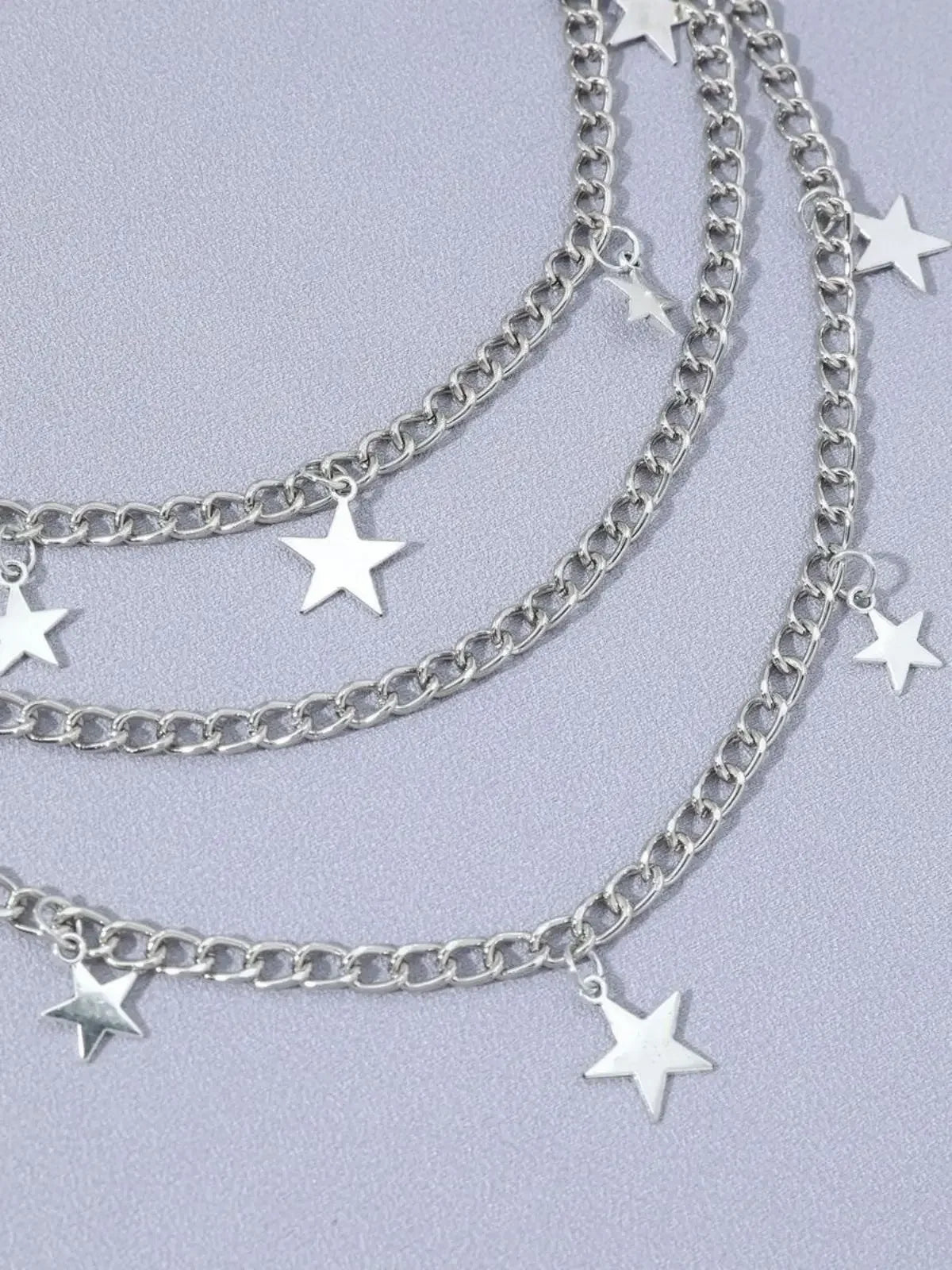 Silver Y2K star charm layered necklace featuring multiple chains and star pendants