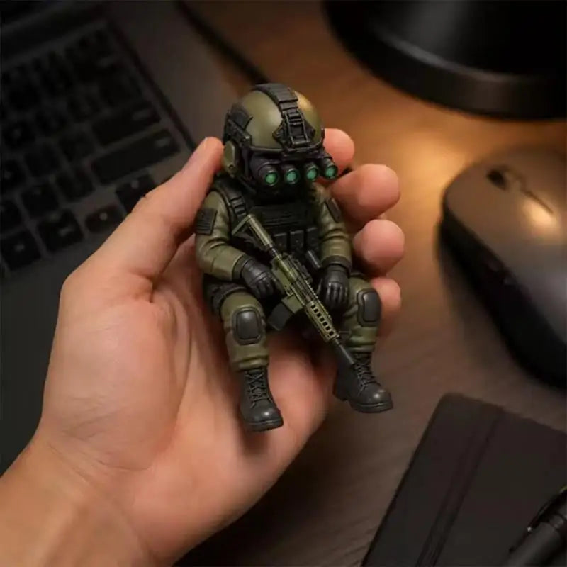 A hand holds a detailed resin collectible statue of a tactical sniper soldier figurine.