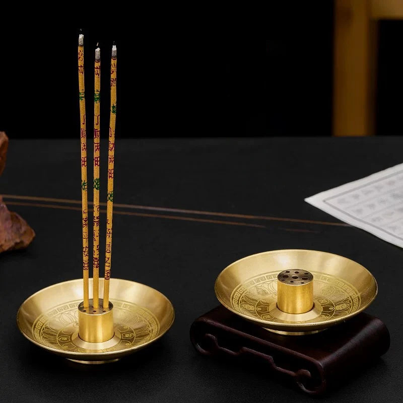 A set of nine incense sticks standing upright in a round gold holder plate on a dark surface.
