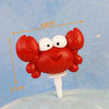 A set of ocean animal cake toppers, including a crab, turtle, octopus, whale, starfish, and shell decor.
