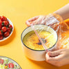 Hands are holding a bowl covered with a reusable elastic food cover, set against a yellow background.