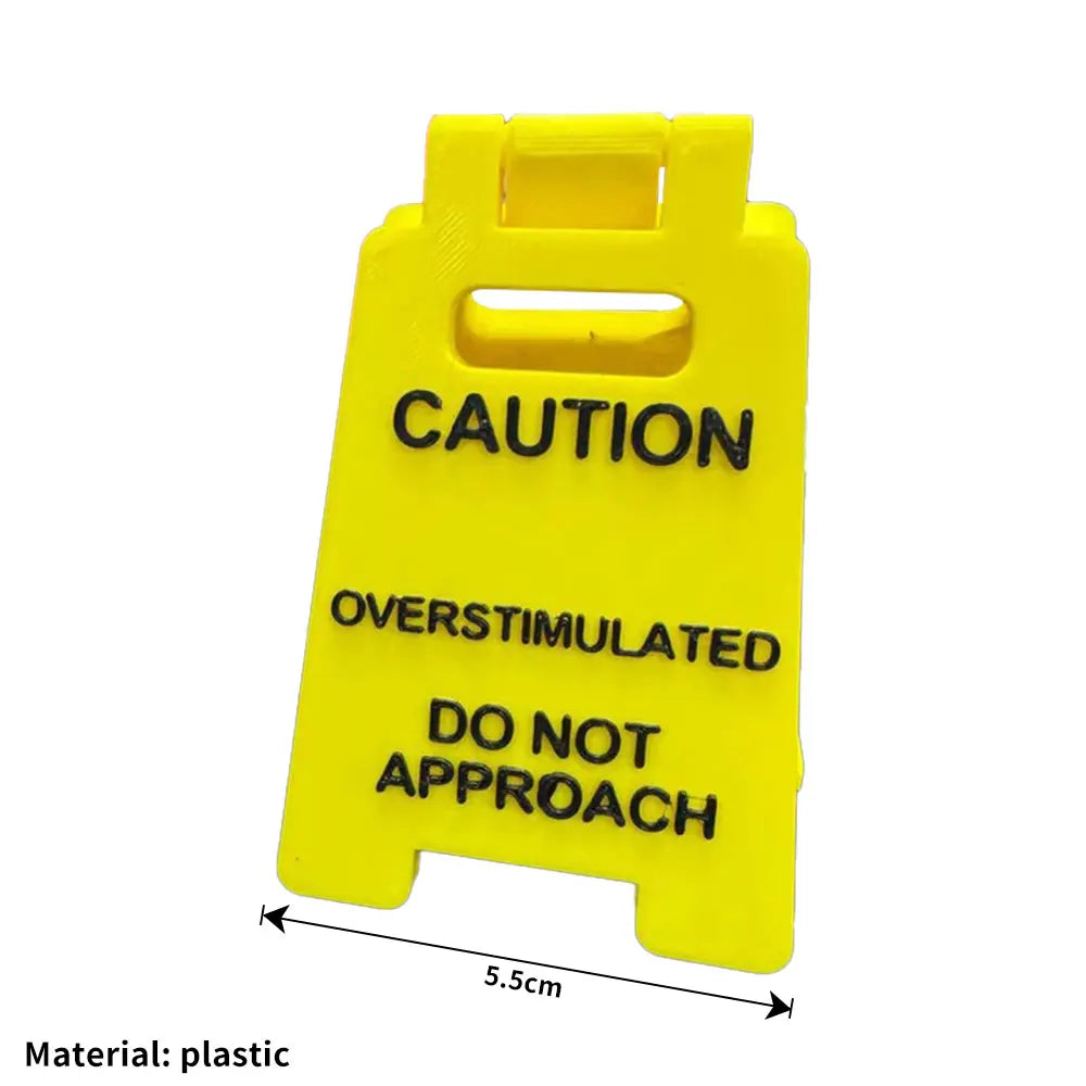 A bright yellow plastic desk sign with black text warning caution and do not approach.