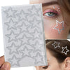 A clear sheet of glitter gems used for stick-on facial tattoos applied to a woman's eye and cheek.