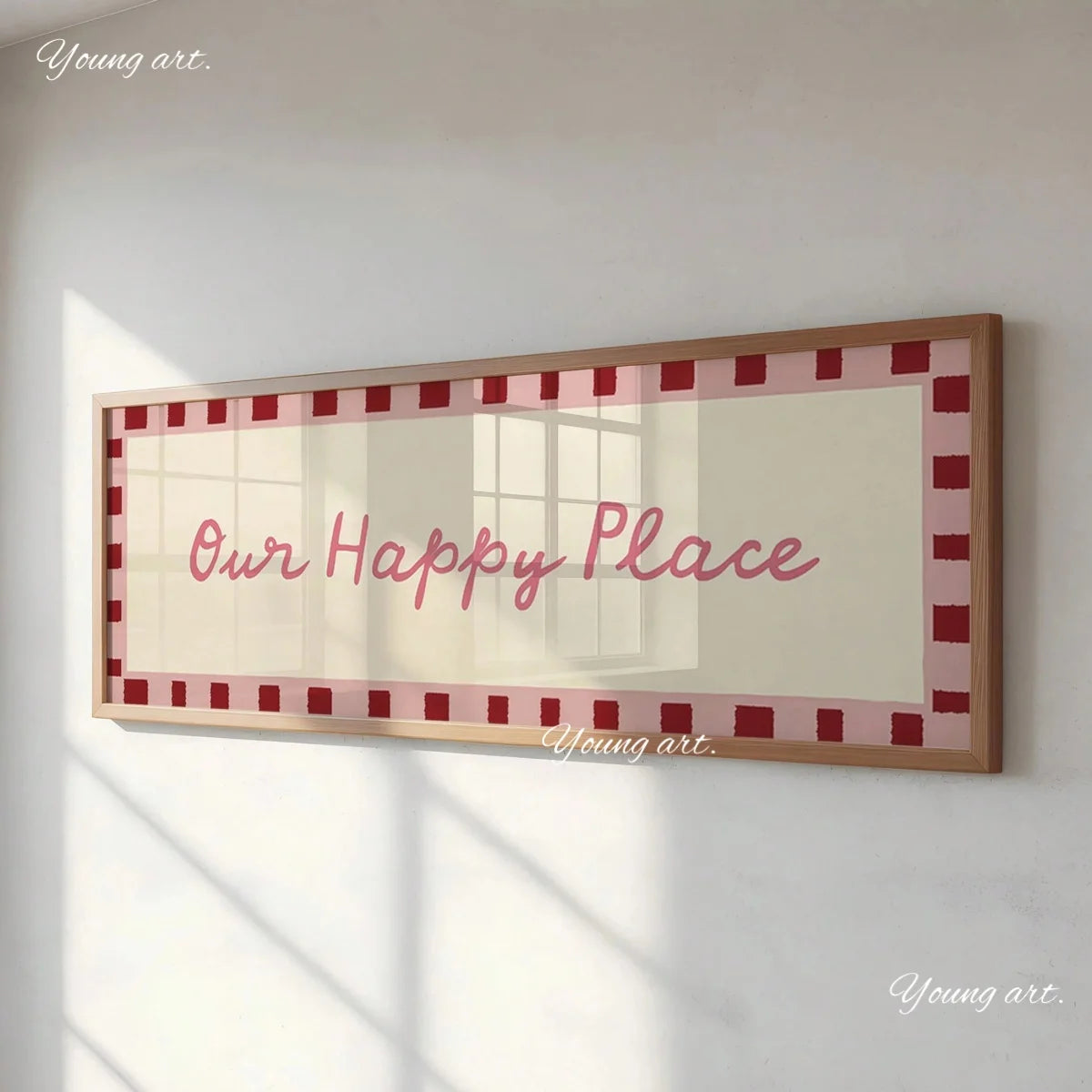 A framed canvas print featuring the text Our Happy Place in pink script on a beige background with a red border.