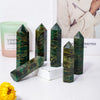 A collection of dark green emerald crystal point healing wands displayed on a white surface.