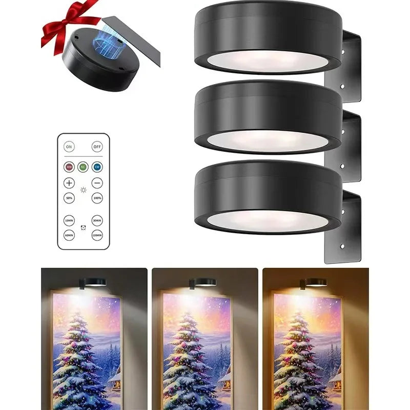 A black LED picture light with a remote control and magnetic mount is shown next to several illuminated picture lights.