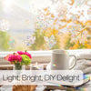 A bright window view featuring holographic film effects on leaves and a mug, suggesting light and DIY delight.