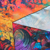 A vibrant tapestry featuring abstract, fiery colors and dark imagery.