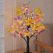 A decorative tree light featuring numerous butterfly-shaped lights in yellow, pink, and purple hues.