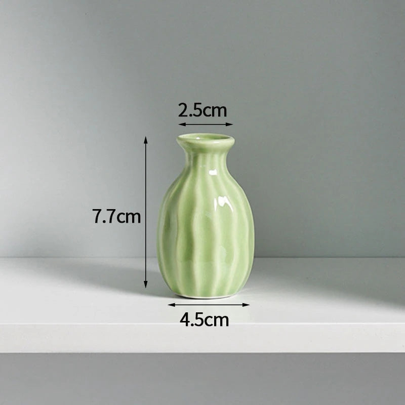 A light green ceramic mini vase with a narrow neck and rounded body, shown against a white background.