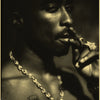A close-up black and white portrait of a man smoking, wearing a gold chain necklace.