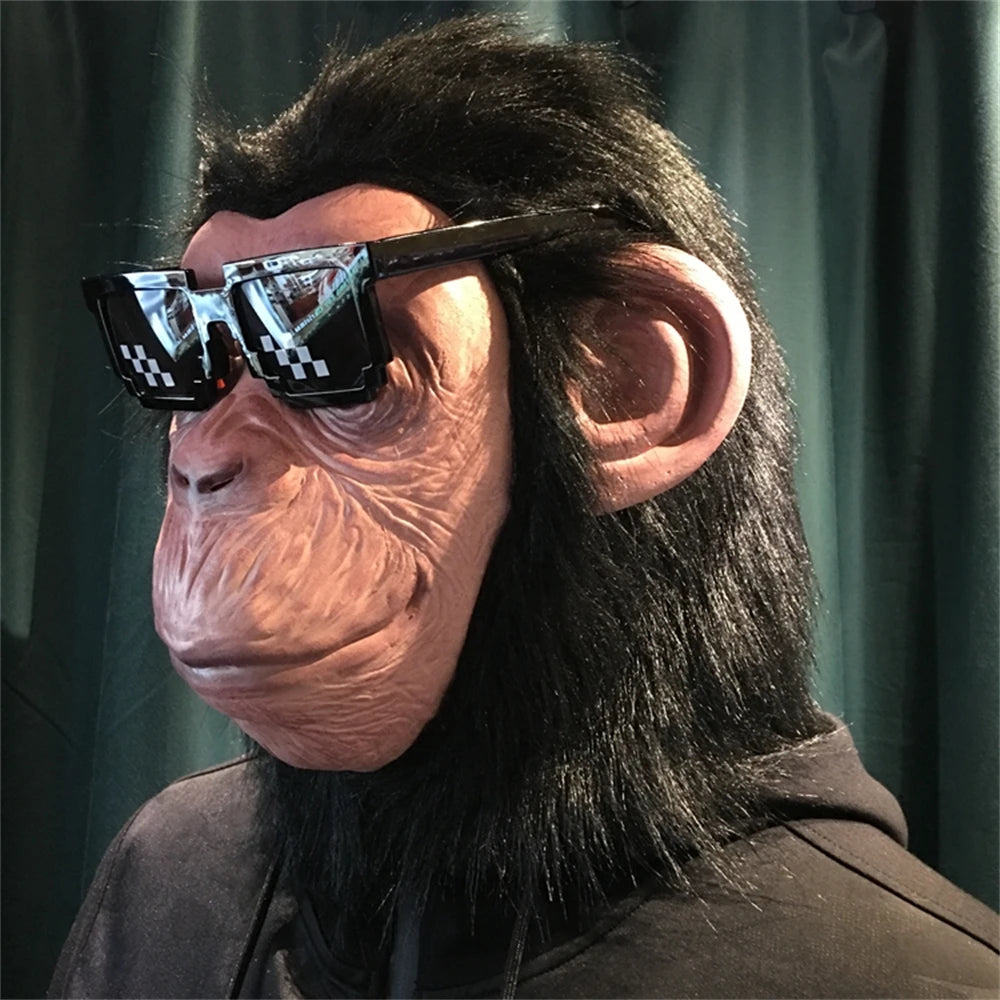 A person wearing a latex monkey mask costume with dark sunglasses and long black hair.