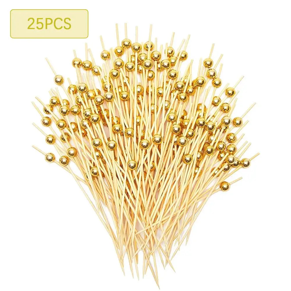 A bundle of gold accent bamboo cocktail skewers with small golden balls for appetizers and fruit.
