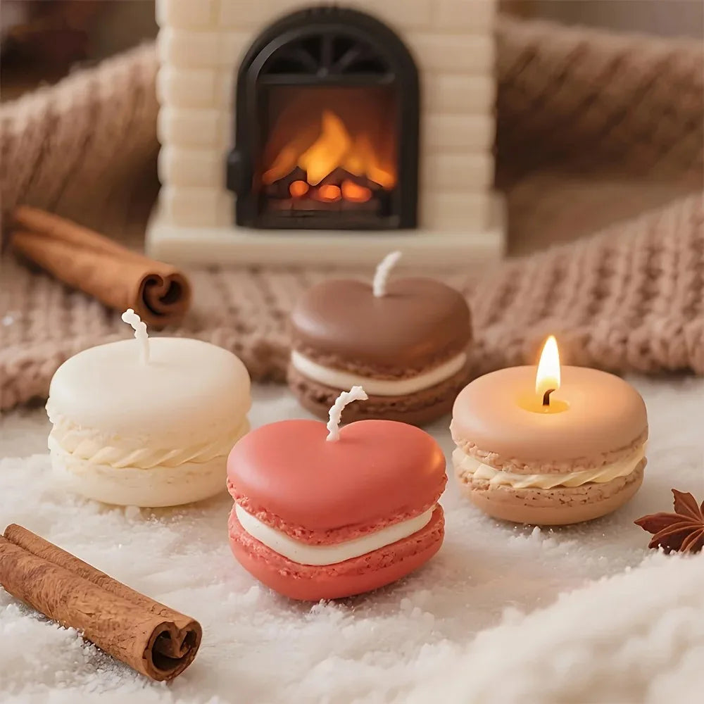 Three macaron-shaped soy wax candles sit on a white surface next to a fireplace and cinnamon sticks.