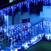 Blue string lights drape over a modern outdoor staircase and building facade.