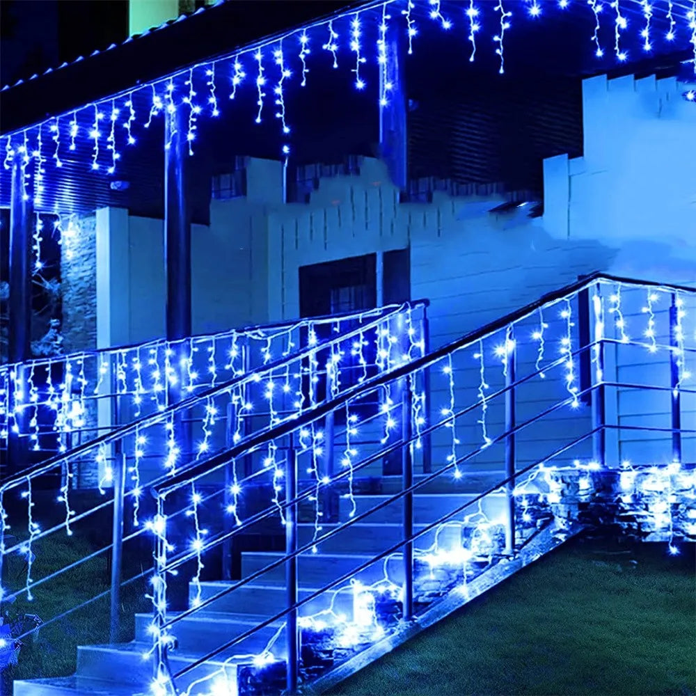 Blue string lights drape over a modern outdoor staircase and building facade.