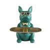 A green bulldog statue wearing sunglasses sitting behind a gold tray.